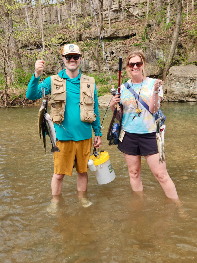 Two fishers holding rainbow trout